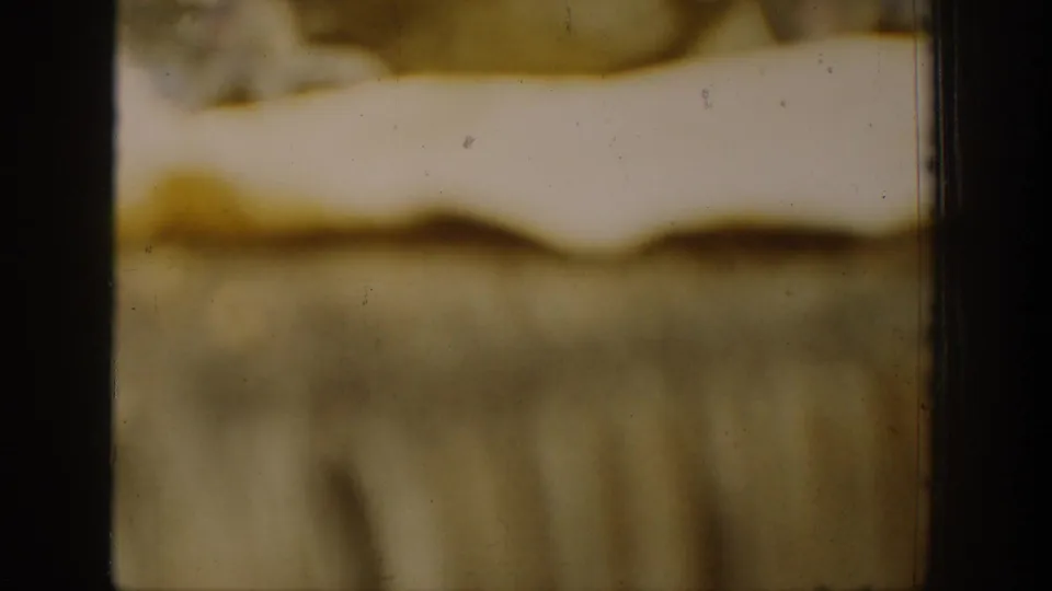 Soft, blurred 1939 Chelan home-movie frame showing indistinct landscape tones, dark film borders, and visible archival film texture.