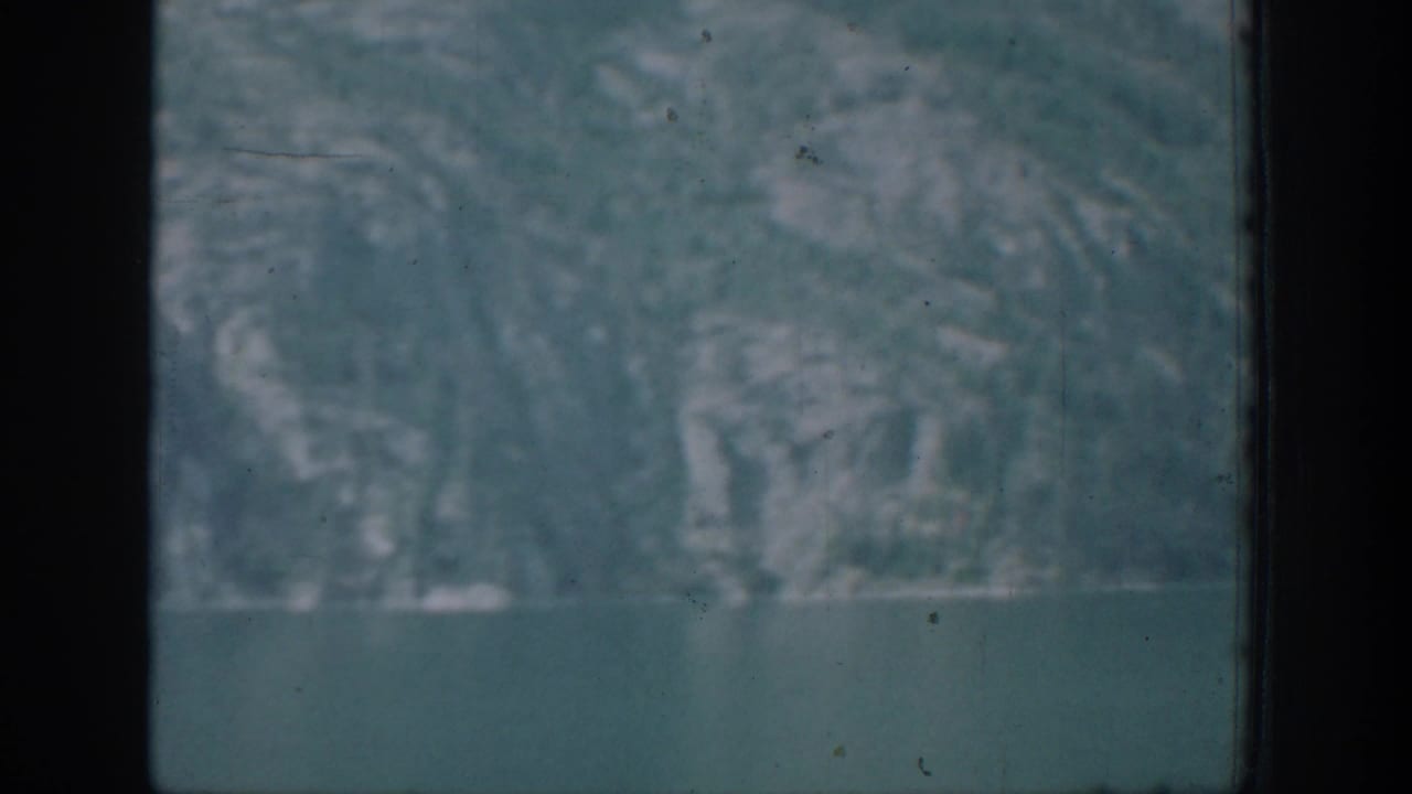 A soft 8mm view shows water in the foreground and a hazy mountainous shoreline, consistent with the Chelan travel setting.