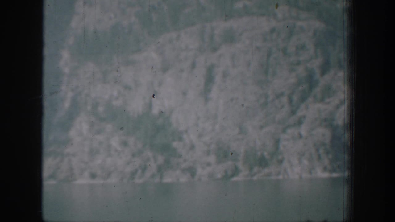 Hazy mountain slope seen through dark window framing.