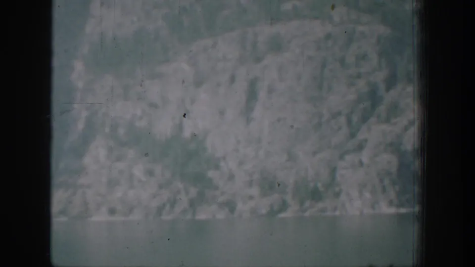 1939 Chelan-area home-movie frame showing a muted mountain slope through a dark window or frame edge.