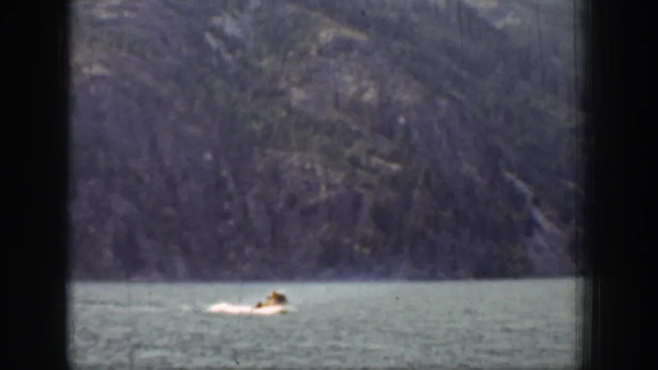 Chelan lake swimming scene from 1939, with the swimmer low in frame and a muted mountain slope filling the background.