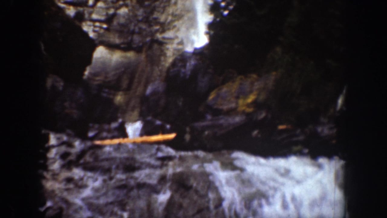 1939 8mm Chelan, Washington view of white water cascading through a rocky, tree-lined gorge.