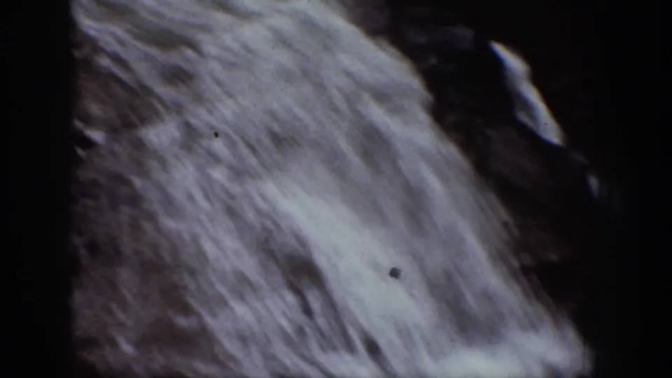 Close 8mm view of a waterfall in Chelan, Washington, with bright water streaking diagonally across dark rock.