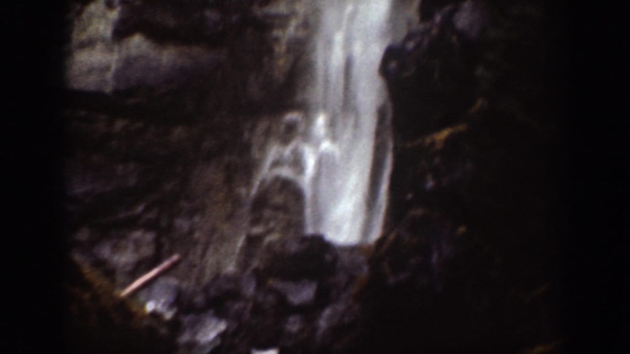 Close view of a waterfall dropping over dark rocks.