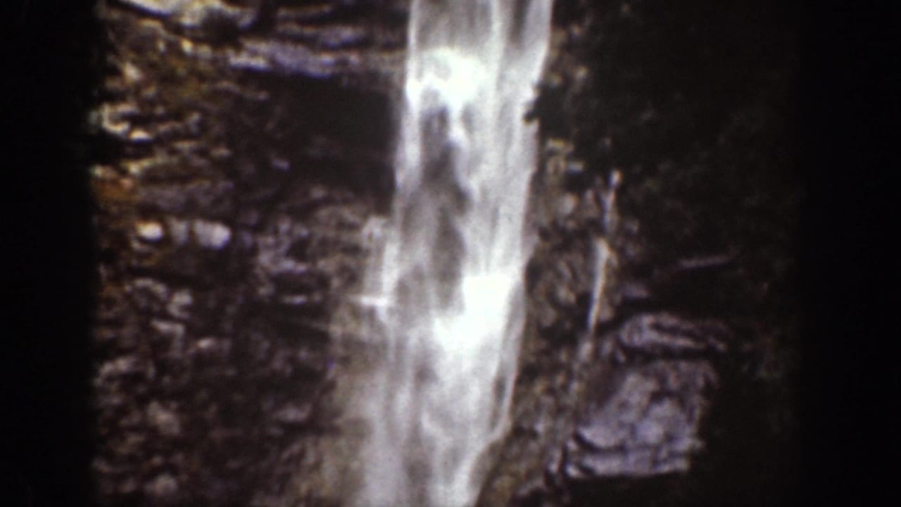 1939 Chelan, Washington home-movie still of a vertical waterfall framed by dark rock walls and deep shadow.
