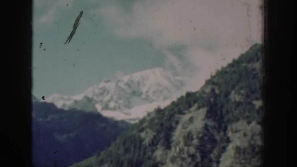 Mountain and forested slopes with a dark film scratch artifact across the frame, likely near Chelan, Washington, circa 1939, 8mm color film.