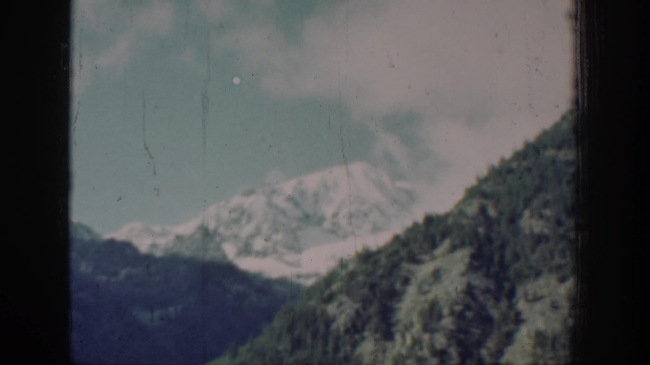 Mountain and forested slopes from a slightly changed viewpoint suggesting movement, likely near Chelan, Washington, circa 1939, 8mm color film.