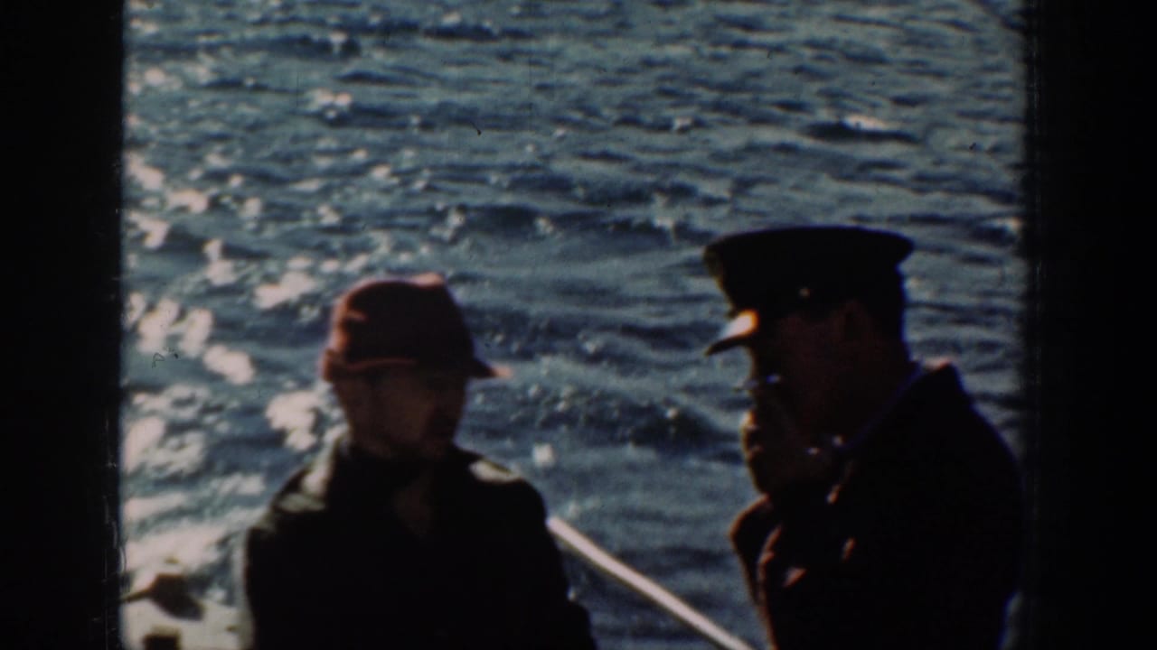 Two men silhouetted on a boat deck against sunlit rippled water, color 8mm film, circa 1939.