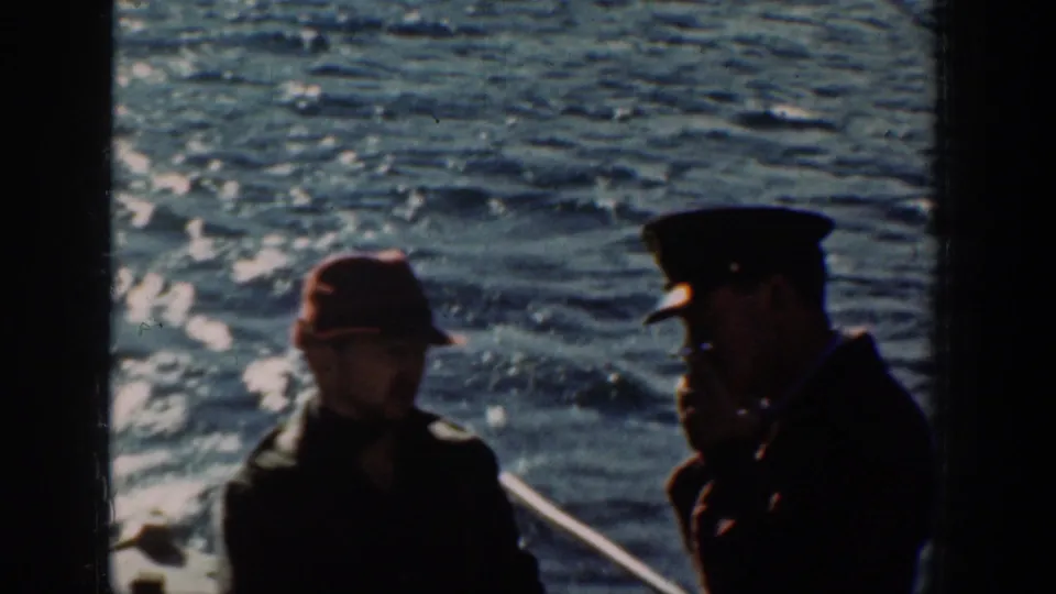 Two figures backlit aboard a boat on open water, possibly Lake Chelan, Washington, circa 1939, with sparkling sunlight on the water surface, color 8mm.
