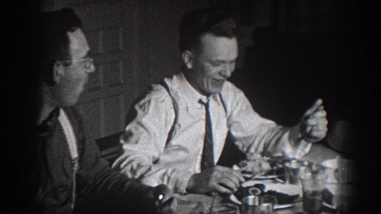 Two men at dinner table; right figure in white shirt, suspenders, and tie laughing animatedly; left figure in darker clothing with glasses.