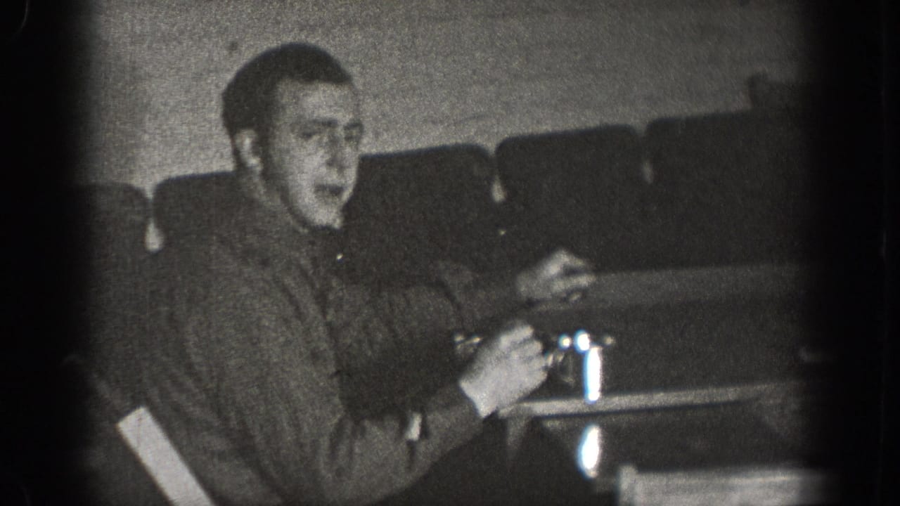 Young man holding a drinking glass at a table in what may be a bar or diner interior, Chelan Washington circa 1939, 8mm home movie footage.