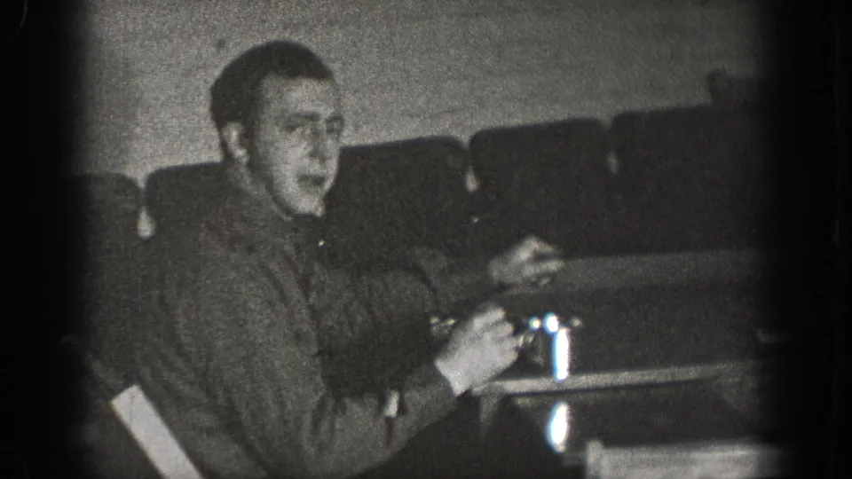 Young man holding a drinking glass at a table in what may be a bar or diner interior, Chelan Washington circa 1939, 8mm home movie footage.