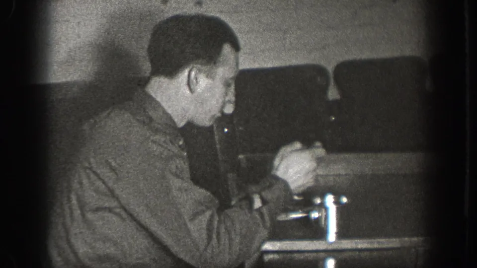 Man eating from a plate at an indoor table with a chrome condiment item alongside, possibly a bar or diner in Chelan Washington, circa 1939, 8mm film.