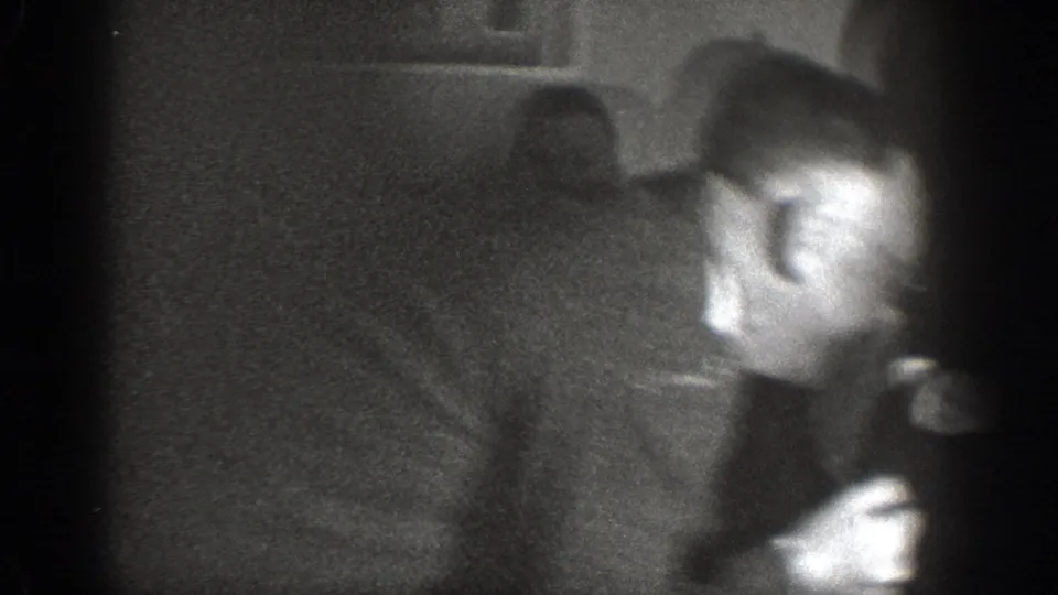 Motion-blurred frame from a 1939 8mm home movie showing a man in a dark suit in mid-movement inside a domestic interior.