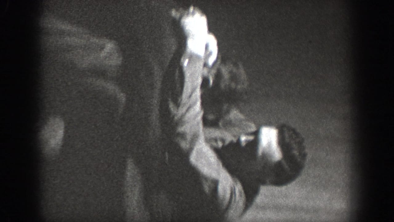 A person in a bent or crouching posture in a dark domestic interior; light areas on clothing contrast with heavily shadowed surroundings, ca. 1939.