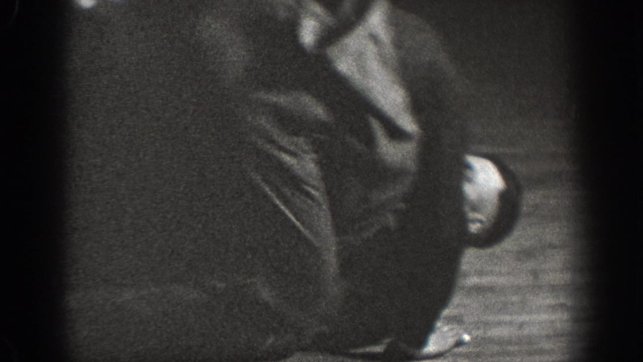 A near-silhouette figure in dark period clothing in a domestic interior; extreme underexposure limits visible detail, ca. 1939.