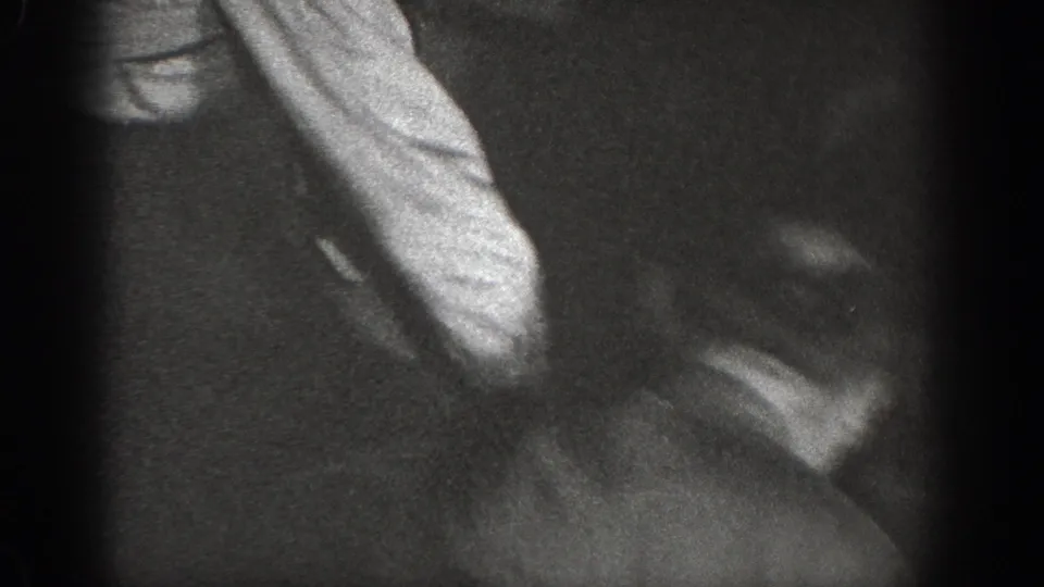 Extreme close-up 8mm home movie frame circa 1939, figure in light fabric with severe motion blur in a dark indoor setting.