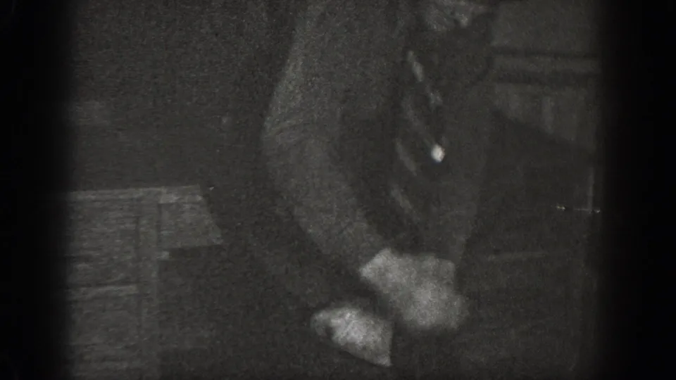 8mm close-up showing a suited man's hands and lower torso leaning forward in a dimly lit interior, consistent with a 1939 home movie from Chelan, Washington.