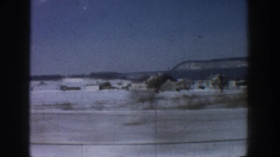 8mm shot from inside a moving car showing a snow-blanketed Colorado valley floor with a mesa on the horizon, circa 1961.