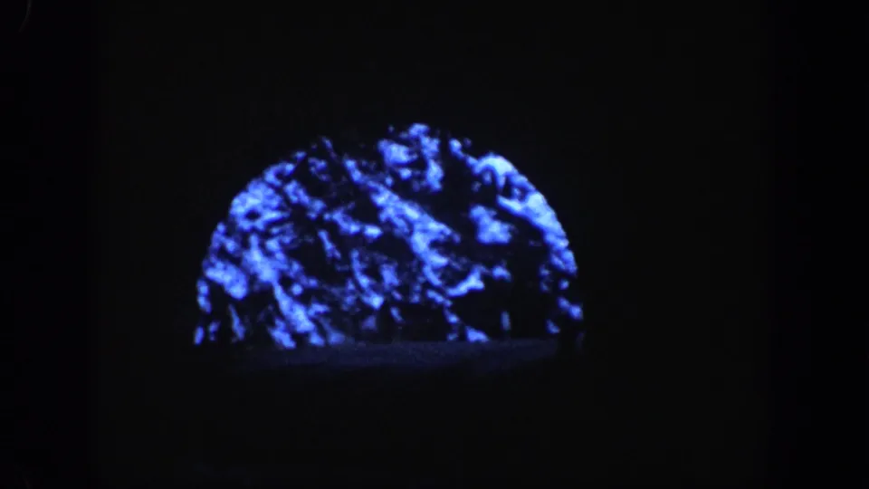 8mm view from inside a mountain tunnel: semicircular entrance arch frames snow-covered rocky peaks beyond, circa 1961 Aspen, Colorado
