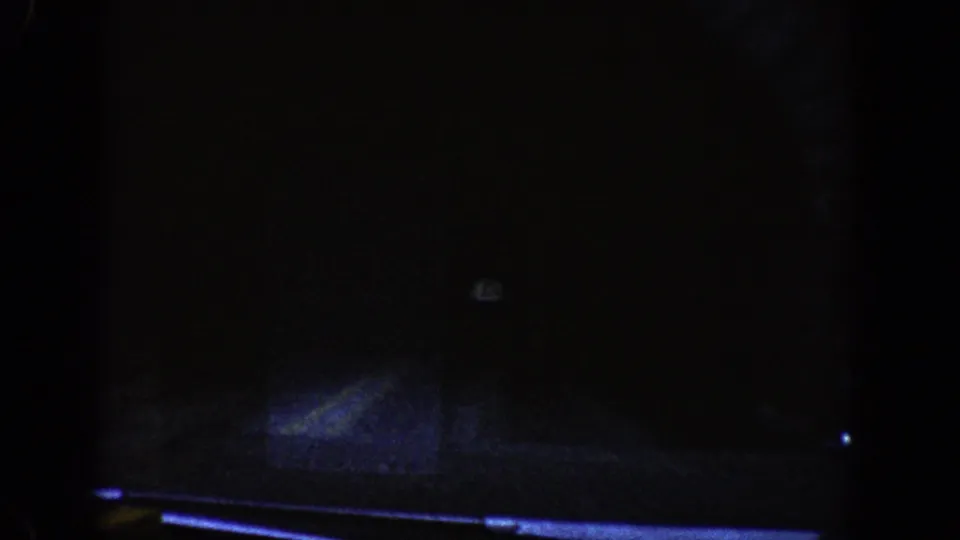 Interior of a mountain road tunnel, circa 1961; exposure drops to near-black with a faint reflection artifact at center.