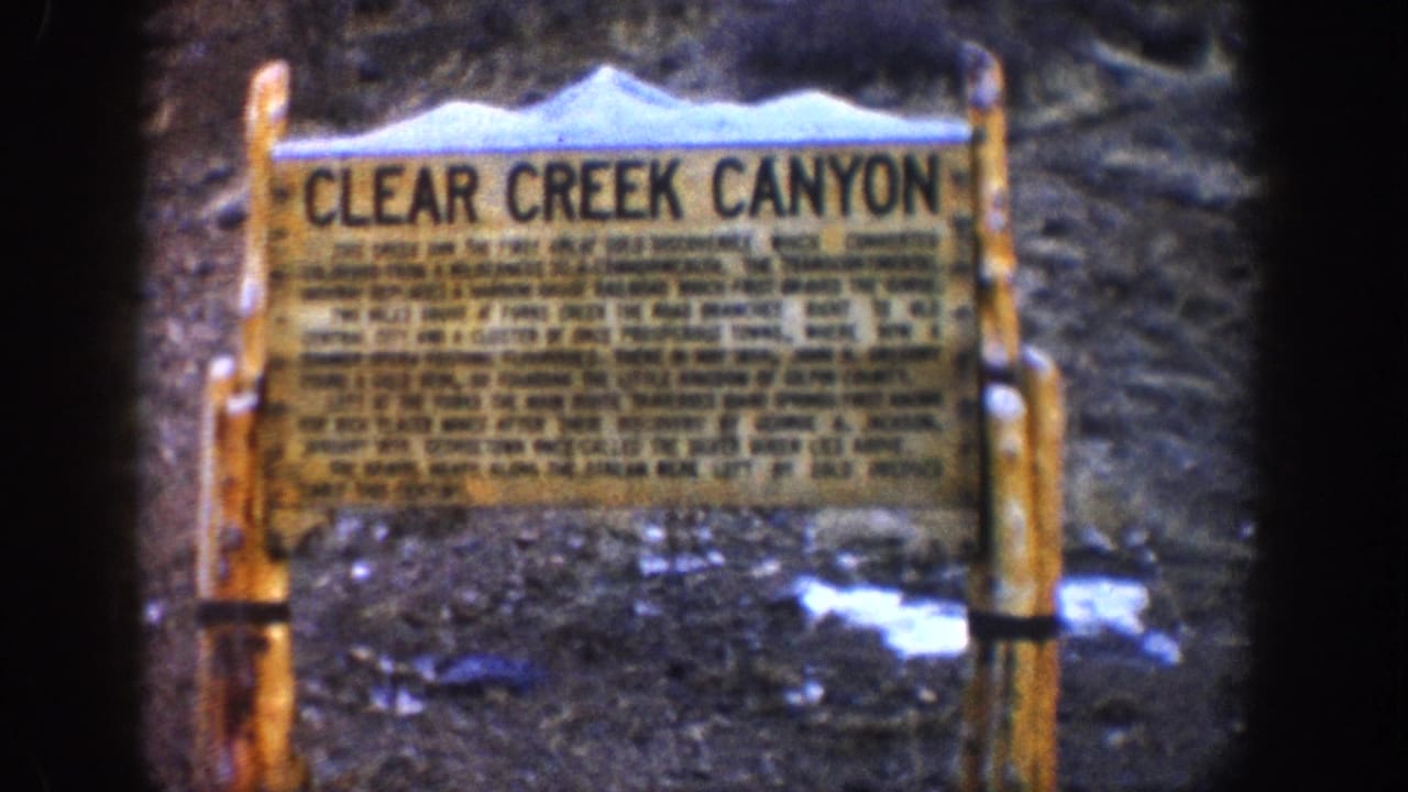 Clear Creek Canyon historical wayside marker, Colorado, circa 1961, wooden framed sign with multi-line interpretive text and snow-patched ground visible in the background.