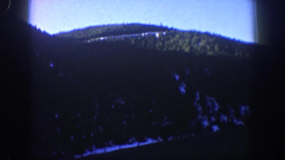 Mountain valley and evergreen-forested slopes filmed on 8mm, consistent with the Aspen, Colorado area circa 1961.