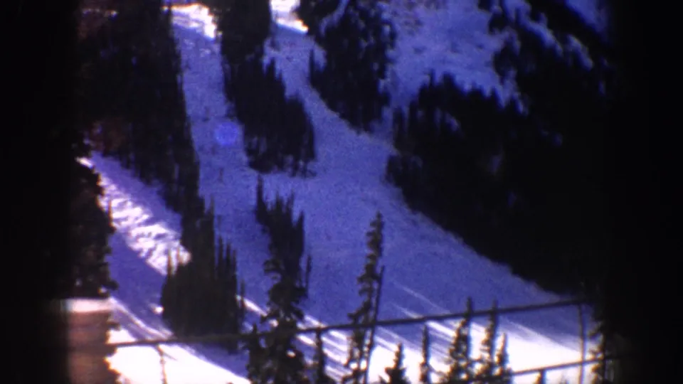 Final 8mm frame circa 1961 showing ski slopes at the Aspen, Colorado area; a horizontal line across the frame may be a window bar or lift cable.