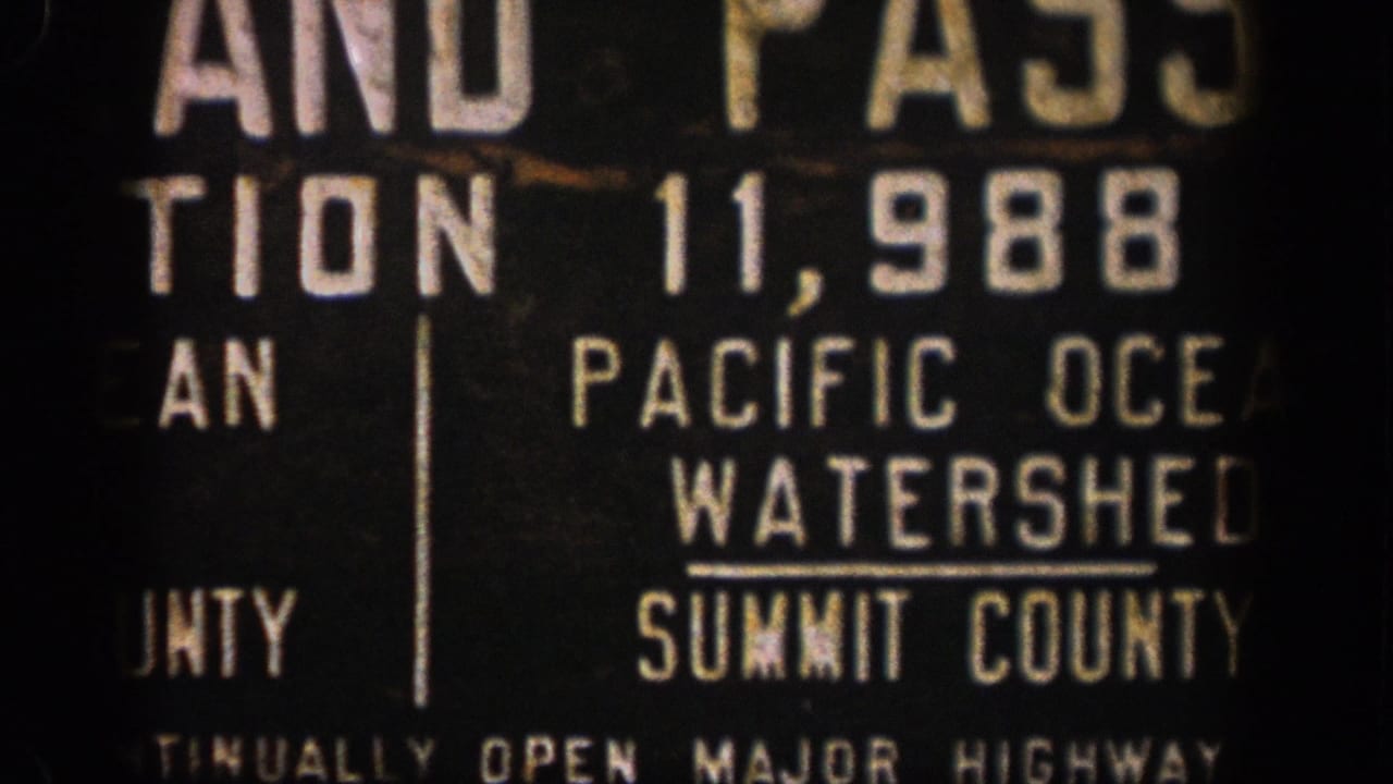 1961 Colorado 8mm frame showing a close, cropped view of a Summit County Pacific Ocean Watershed sign with population numbers.