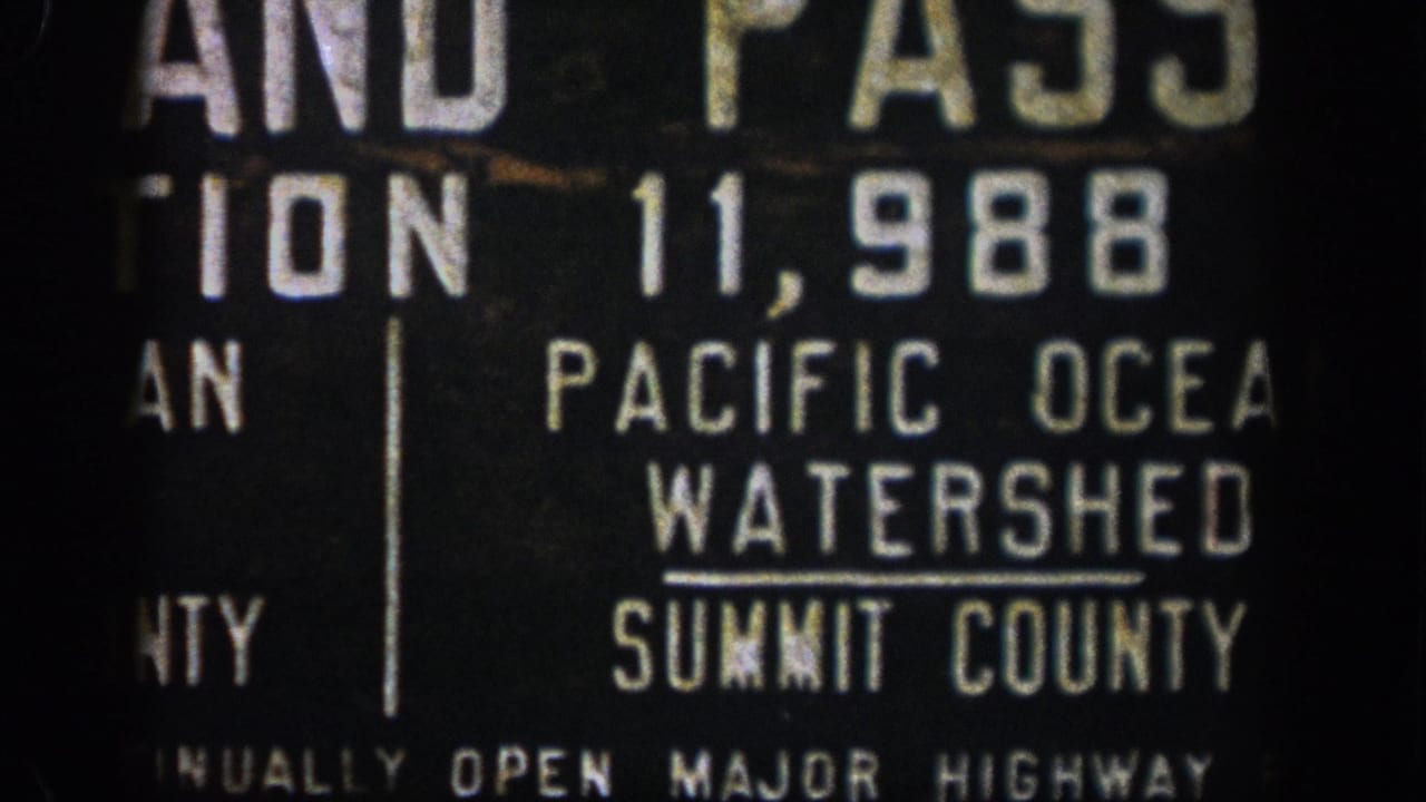 Close-up of Pacific Ocean Watershed and Summit County lettering on a dark sign.