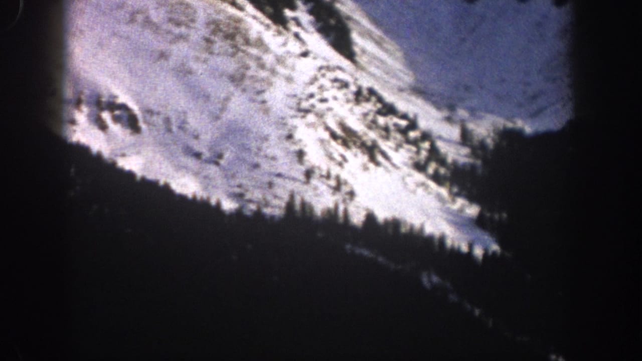 Snow-covered ridgeline with dark tree line across the lower frame.