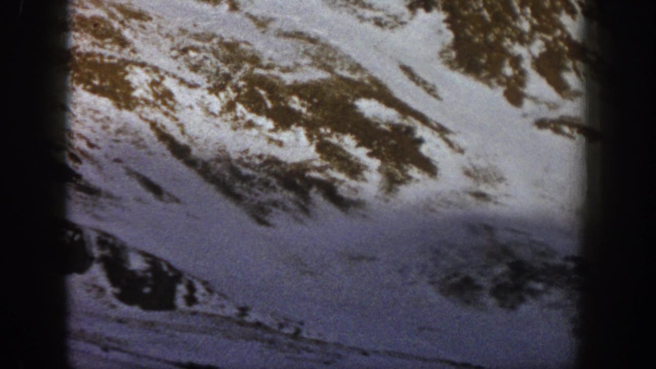 Snowy Rocky Mountain terrain at Loveland Pass in archival 1961 8mm footage, framed with dark film edges.