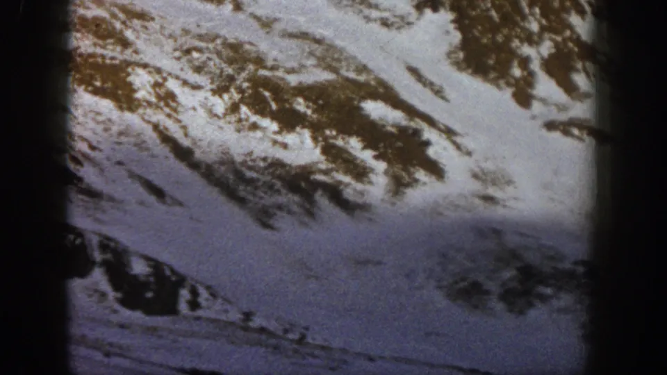 Snowy Rocky Mountain terrain at Loveland Pass in archival 1961 8mm footage, framed with dark film edges.