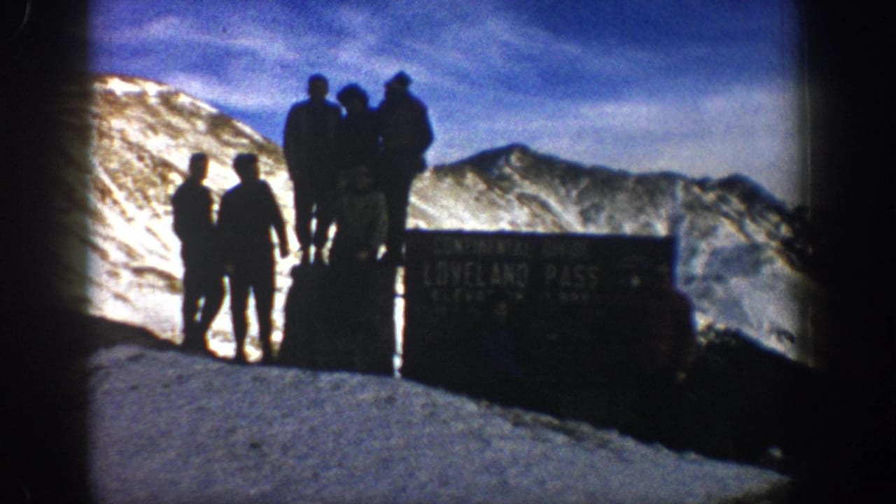 The final frame shows men silhouetted at Loveland Pass beside public signage, with snow, blue sky, and ridgelines behind them.