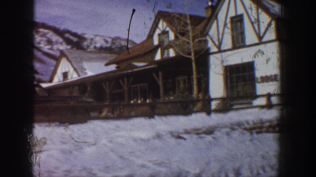 Tyrolian-style white stucco lodge with dark timber framing and snow-covered ground, Aspen Colorado area, circa 1961, 8mm home movie.