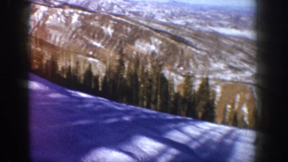 Continuation of opening view — purple-blue shadowed snow slope, diagonal shadows, conifer belt, and ridgeline; Aspen, Colorado area, circa 1961, 8mm film.