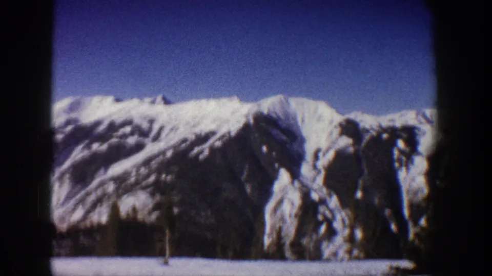 8mm home movie frame of snow-covered peaks and snow-laden conifer trees in the foreground, Aspen area, Colorado, circa 1961