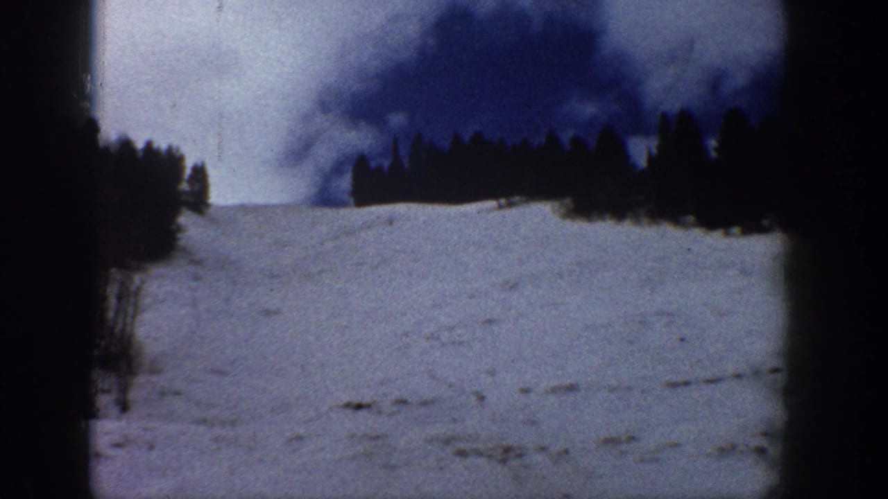Open snow-covered ski run with a dense conifer treeline silhouetted against dramatic dark cloud formations, consistent with a Colorado mountain setting, circa 1961.