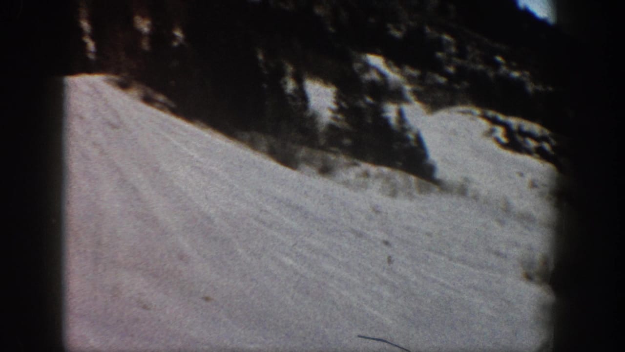 Close view of a snow-covered ski slope with conifers, from 8mm home movie footage likely shot at Aspen, Colorado, circa 1961.