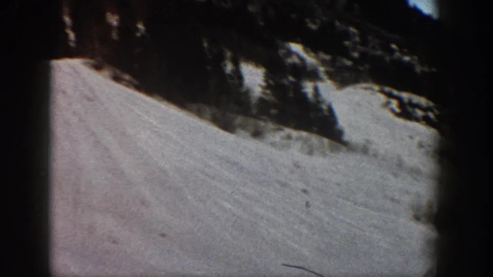 Close view of a snow-covered ski slope with conifers, from 8mm home movie footage likely shot at Aspen, Colorado, circa 1961.