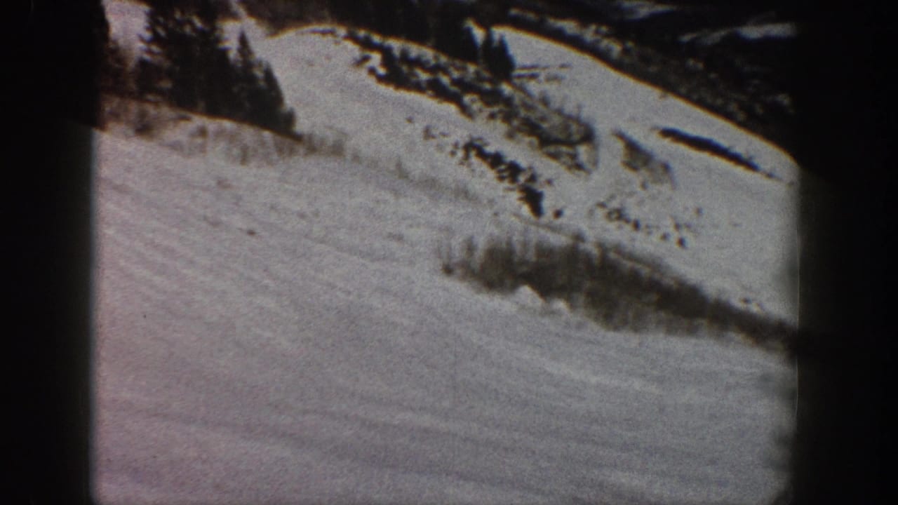 Snowy hillside with conifers and snow-covered brush, from 8mm home movie footage likely shot at Aspen, Colorado, circa 1961.