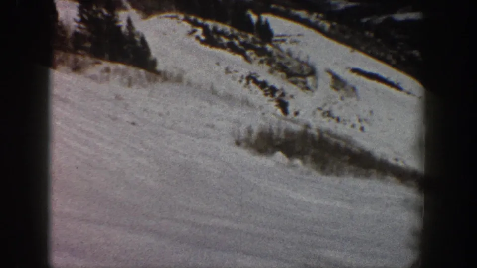 Snowy hillside with conifers and snow-covered brush, from 8mm home movie footage likely shot at Aspen, Colorado, circa 1961.