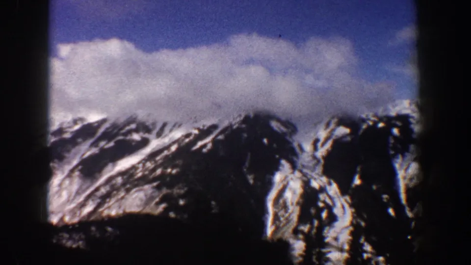 Colorado Rocky Mountain peaks with snow and partial cloud cover filmed on 8mm, Aspen area, circa 1961.