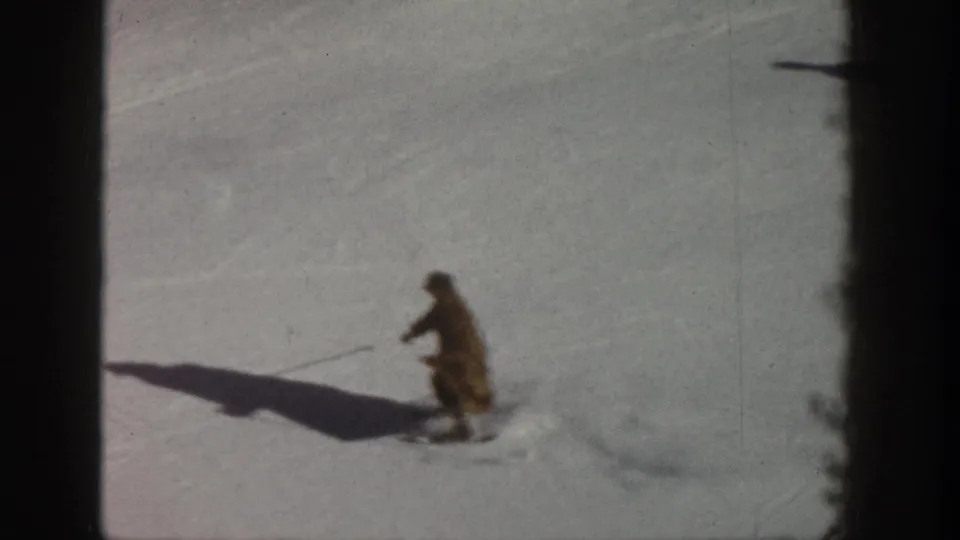 8mm home movie circa 1961, Aspen Colorado — skier in crouched stance holding poles, mid-run on open snow slope.