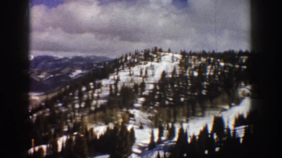 8mm home-movie frame of a broad Colorado alpine valley in winter with multiple snow-covered ridgelines, ca. 1961.