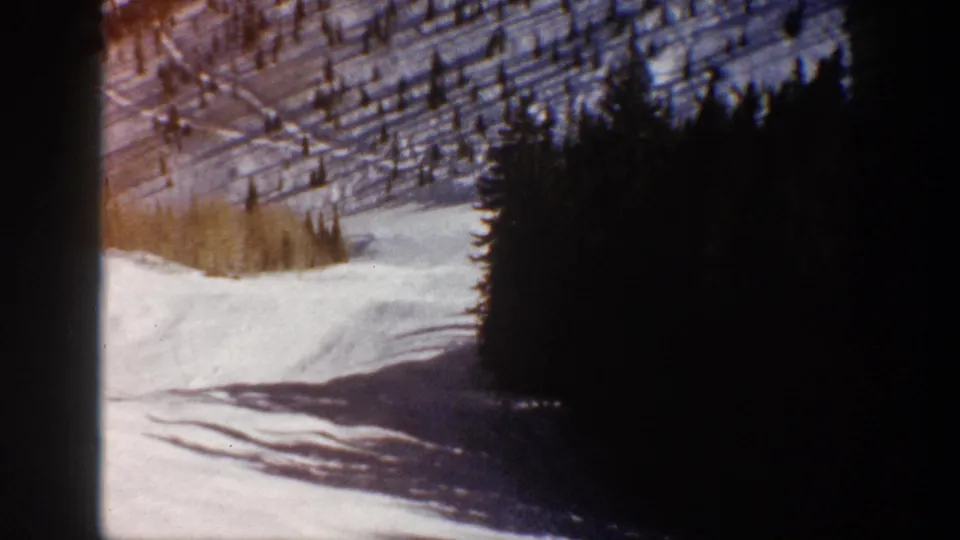 Final sampled frame of the 1961 Aspen road shot, with snow, forest edge, hillside, and dark gate-edge exposure.