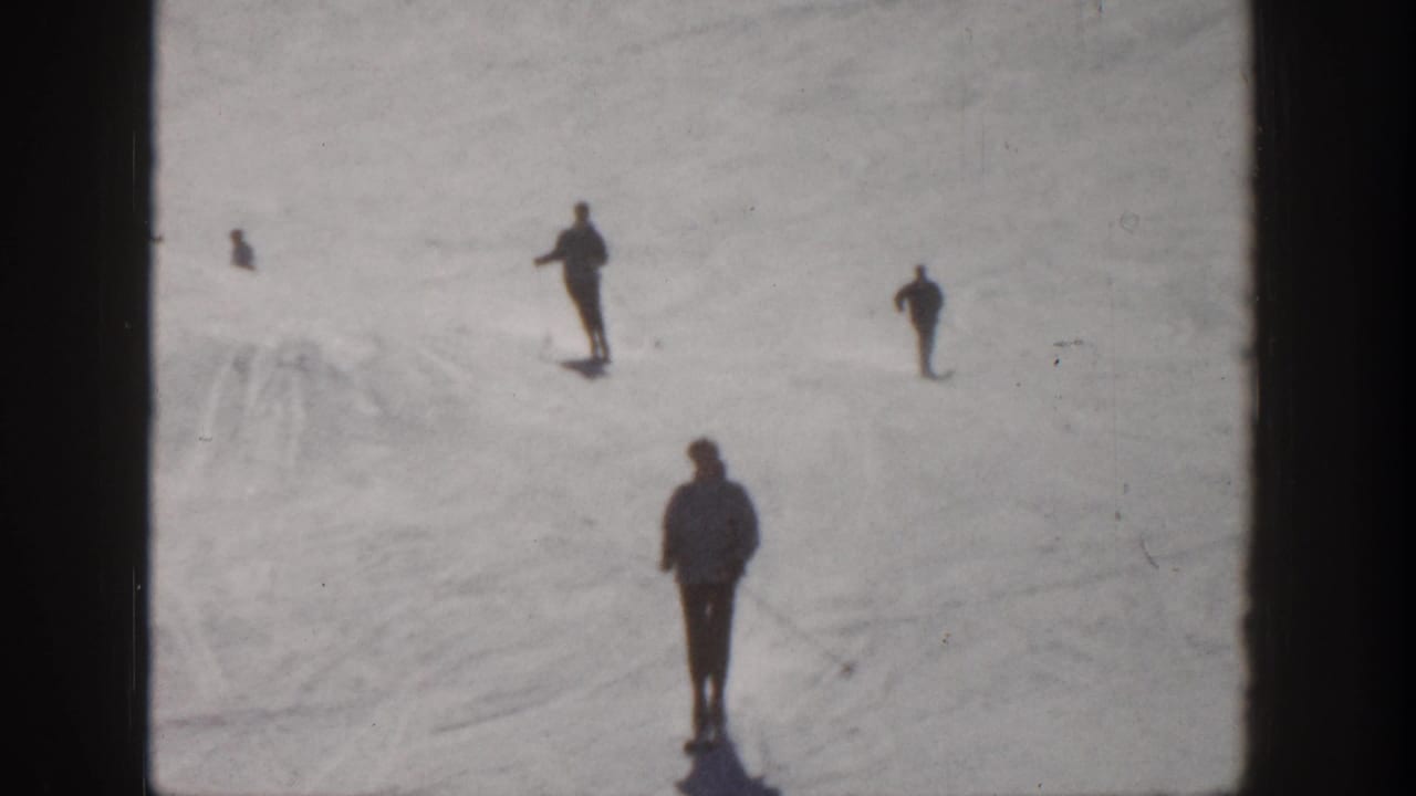 Aspen, Colorado 1961 home-movie frame showing several distant skiers on a snow-covered slope, with one foreground figure.