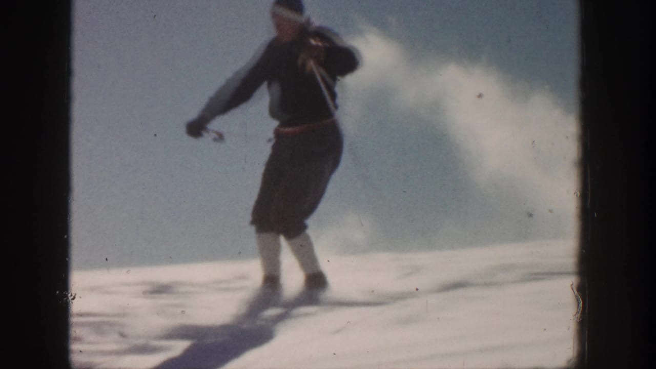Adult skier in knee-length trousers and white socks turns across snow in Aspen, Colorado, 1961.