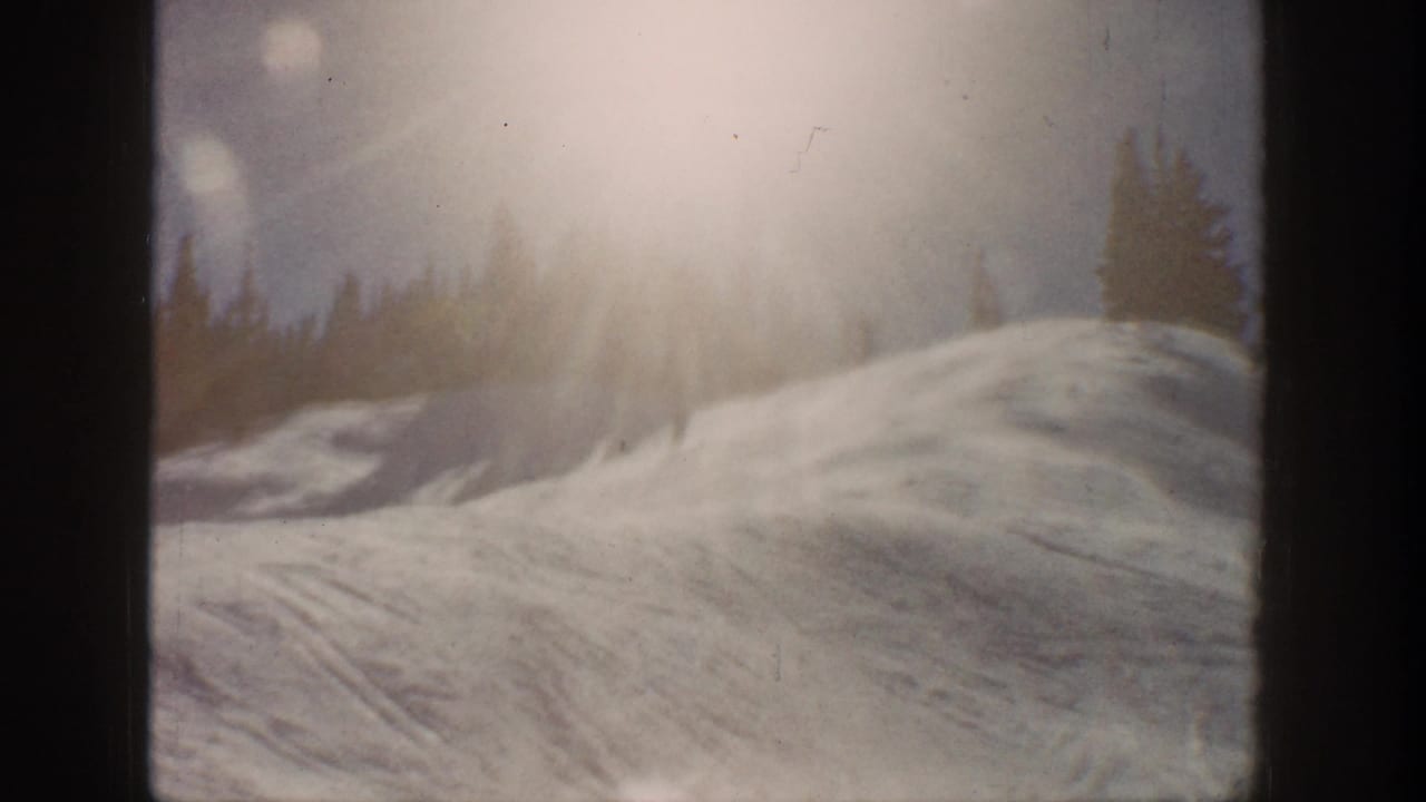 Aspen, Colorado 1961 home-movie frame showing a sunlit snow slope, tree line, lens flare, and dark film gate edges.