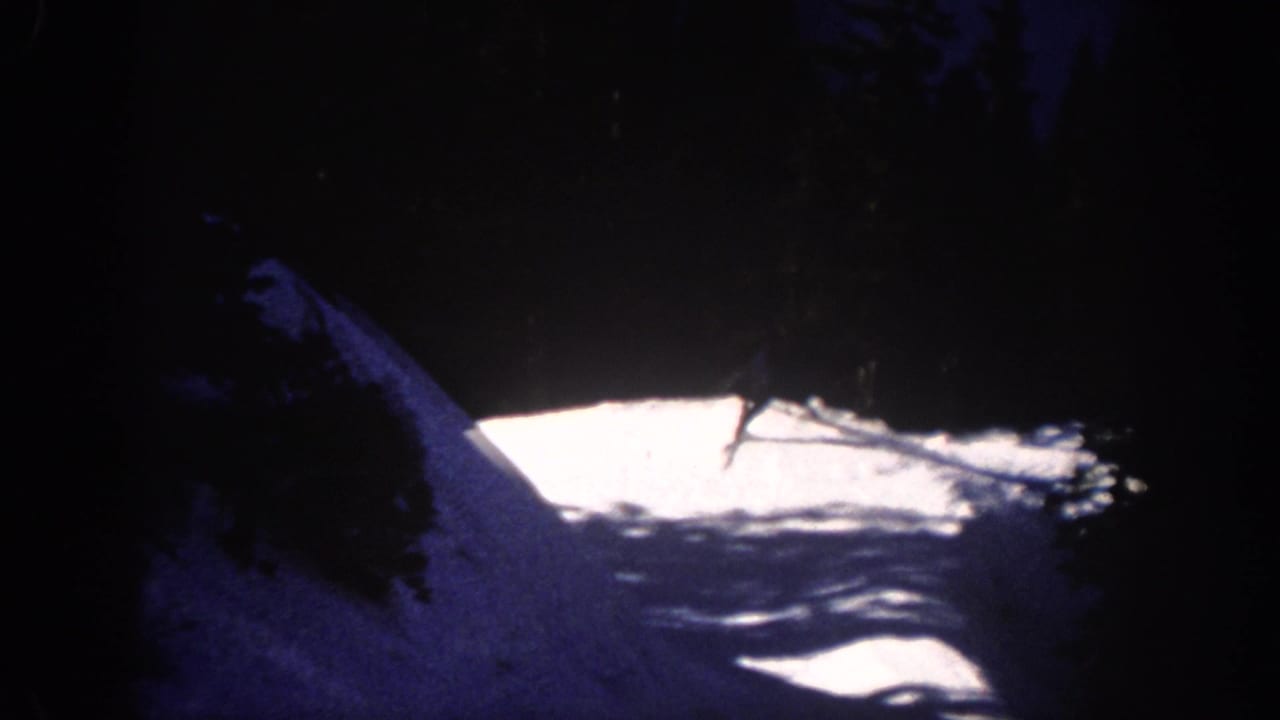 A distant skier glides across an artificially lit snow slope in Aspen, Colorado, in 1961 home-movie footage.